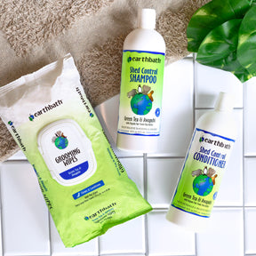 Pack of grooming wipes, shed control shampoo and shed control conditioner over the floor