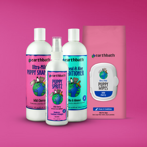 Collection of Earthbath pet care products including bottles and wipes on a pink background